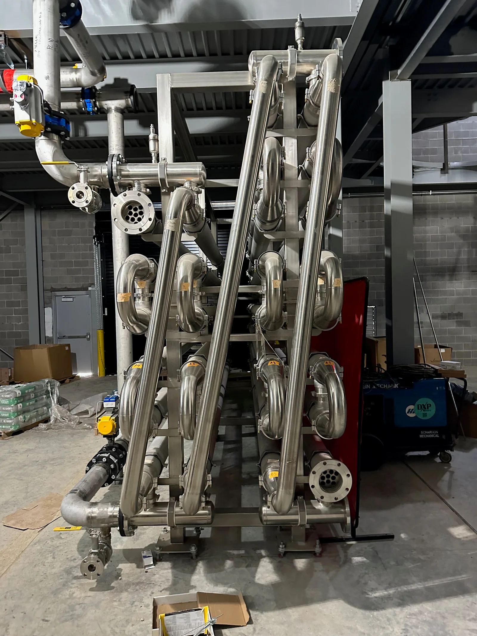 The open end of a large stainless steel heat exchanger showing the bank of tubes.